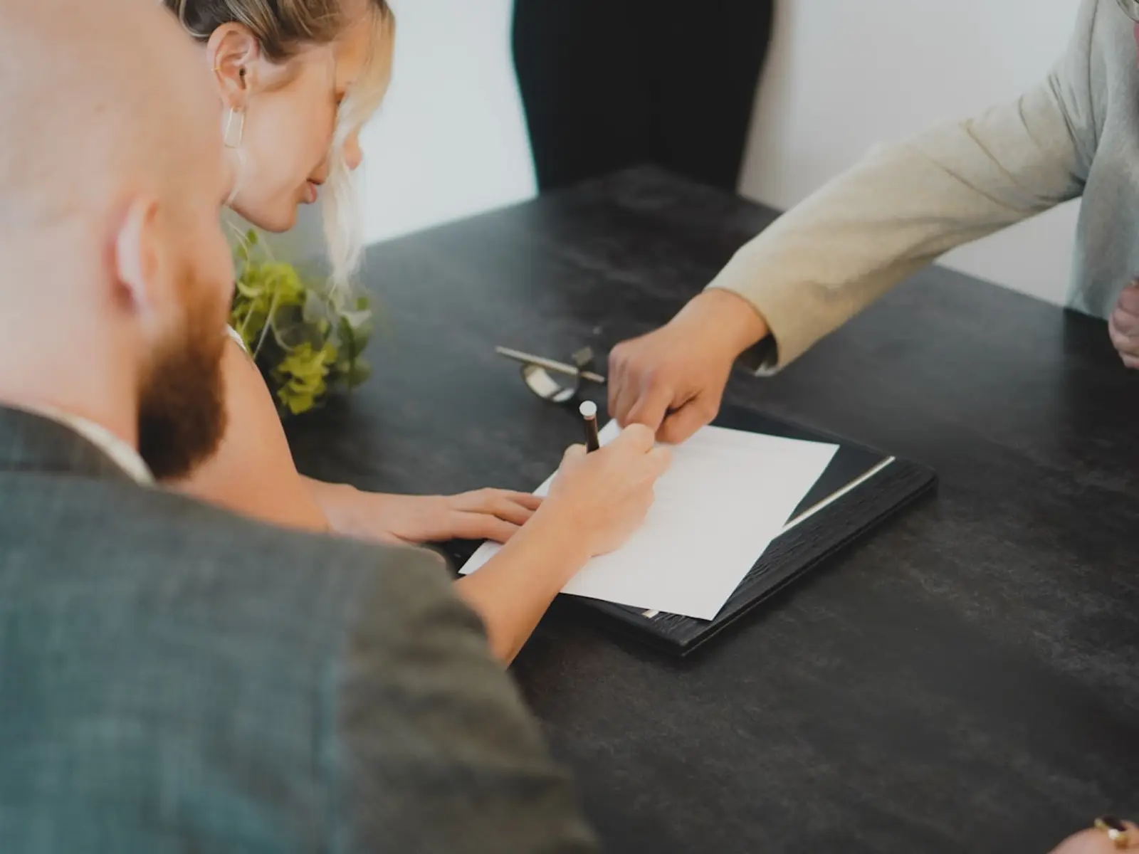 Clients signing a building contract across a table